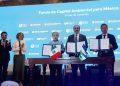 Four officials stand behind a wooden table signing an environmental agreement, Mexican and regional flags visible, blue backdrop reads 'Fondo de Capital Ambiental para México'.