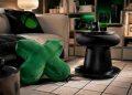 Cozy living room corner with a green X-shaped cushion, a black round coffee table, and an Xbox mug on a tray.