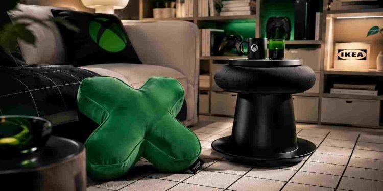 Cozy living room corner with a green X-shaped cushion, a black round coffee table, and an Xbox mug on a tray.